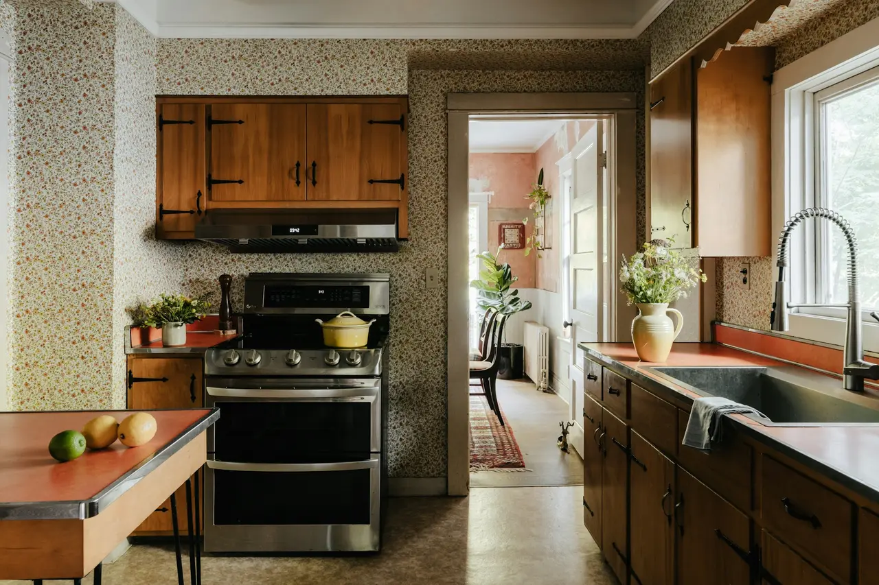 Cozinha antiga, com bancada laminada alaranjada e papel de parede estampado