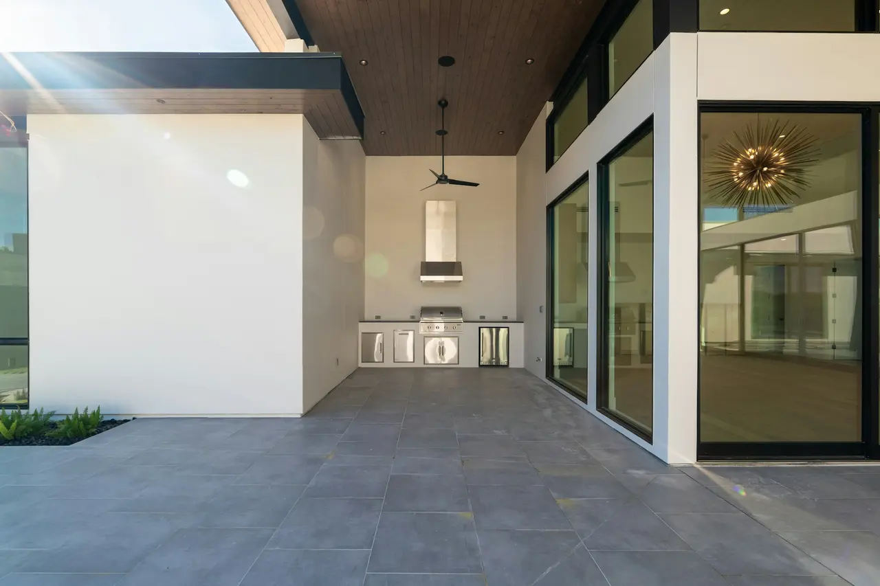 Pátio amplo com cozinha externa e porta de vidro para a sala