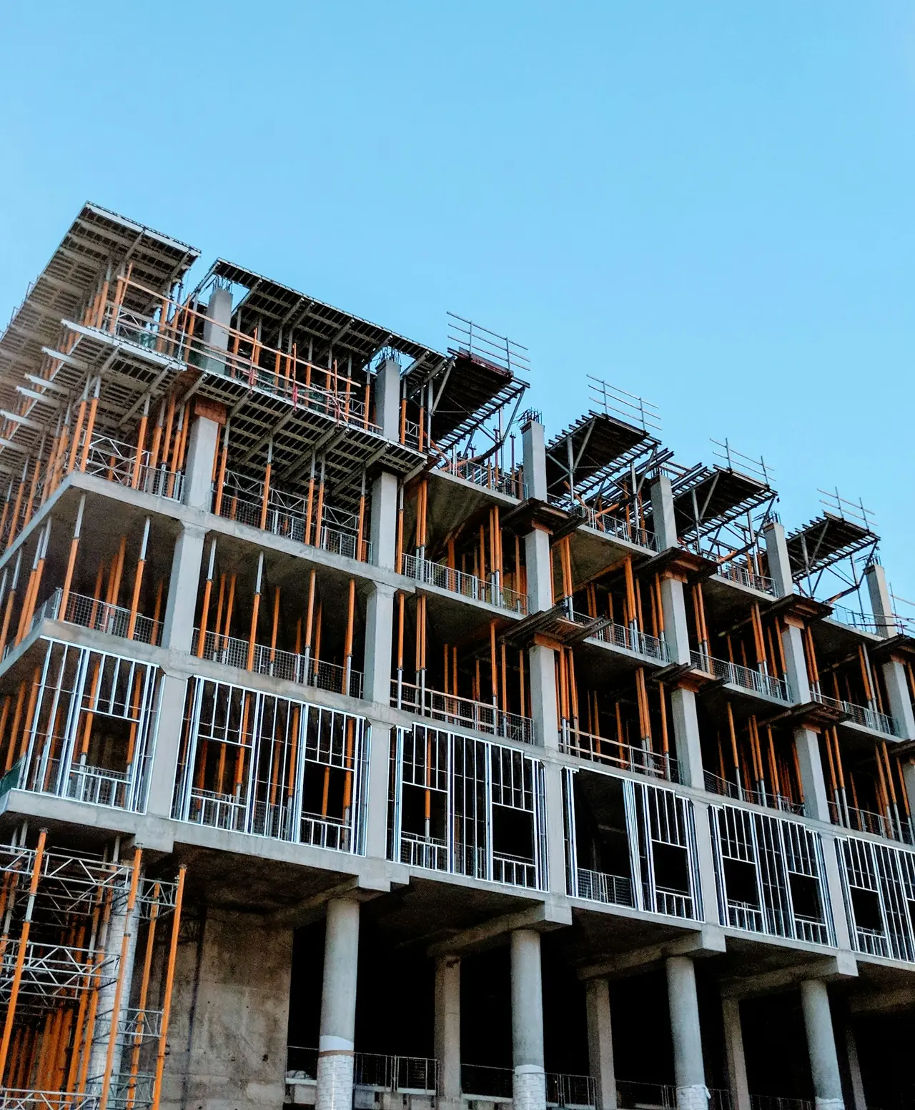 Edifício residencial em construção visto de baixo, com estrutura de concreto aparente